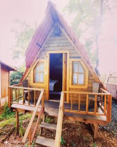Cabaña de madera pequeña con porche y puerta en Aqui no Camping, en Brumadinho