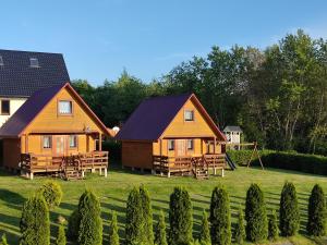 due cottage in un cortile con parco giochi di Domki Letniskowe Kama 514 - 280 - 102 a Solina