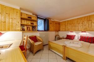 una camera con letto, scrivania e sedia di Casa Alice a La Thuile