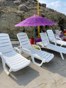 4 ligstoelen en een parasol op het strand bij Çanak tatil sitesi in Mersinli
