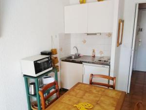 a small kitchen with a table and a microwave at STUDIO Climatisé proche plage 4 PERS in Cavalaire-sur-Mer +2 photos