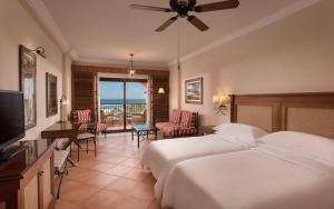 Habitación de hotel con cama y balcón en Sheraton Fuerteventura Golf & Spa Resort en Caleta de Fuste