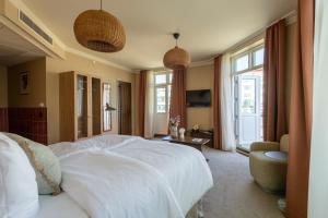 a bedroom with a large white bed and a window at Grand Joanne in Copenhagen