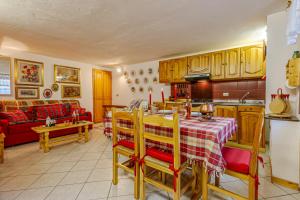 una cucina e un soggiorno con tavolo e divano di Casa Alice a La Thuile