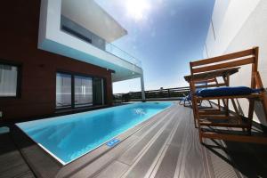 a house with a swimming pool on a balcony at Luxury Oceanview Villa with Private Pool in Ericeira