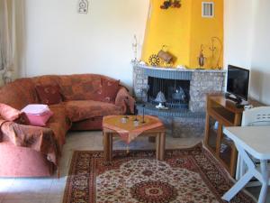 a living room with a couch and a fireplace at Εξοχικό με θέα στον Όλυμπο in Skotina