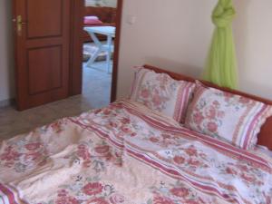 a bedroom with a bed with a floral comforter at Εξοχικό με θέα στον Όλυμπο in Skotina