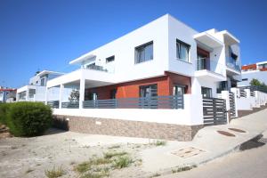 a house on the beach with a blue sky at Luxury Oceanview Villa with Private Pool in Ericeira