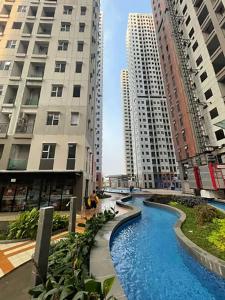 a river in the middle of two tall buildings at Transpark Juanda by 21 Room in Bekasi