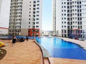 a large swimming pool in a city with tall buildings at Transpark Juanda by 21 Room in Bekasi