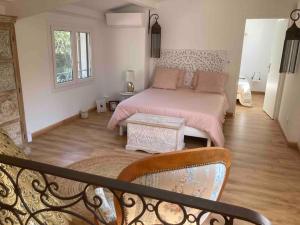 1 dormitorio con 1 cama con sábanas rosas en La Balouvière Villa entre Cévennes et Provence, en Laudun