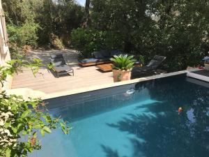 una piscina con terraza de madera y una piscina en La Balouvière Villa entre Cévennes et Provence, en Laudun