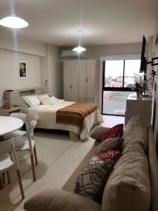 ein Wohnzimmer mit einem Bett und einem Sofa in der Unterkunft Departamento del Parque in San Miguel de Tucumán