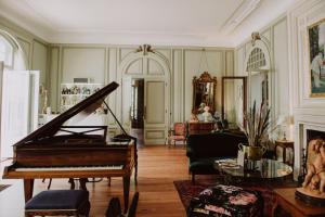 Zimmer mit einem Klavier und einem Wohnzimmer in der Unterkunft Château du Clair de Lune - Teritoria in Biarritz