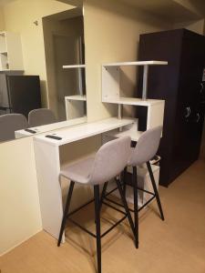 a desk with two chairs and a desk with shelves at AVIDA TOWER Free Airport Pick up for 3 nights stay or more in Davao City