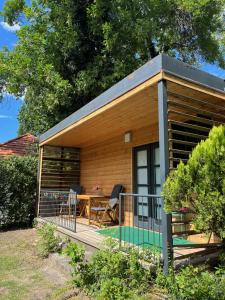 una casa pequeña con terraza y mesa en Málna Privát Nyaraló, en Balatonlelle