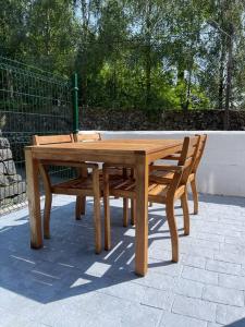 a wooden table and two chairs sitting next to a fence at Bajo con Terraza Asón River in Limpias
