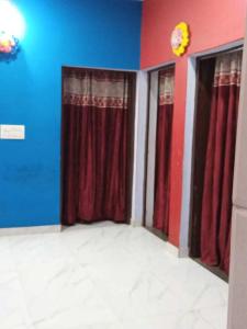 a room with three windows with red curtains at POP Pinki Homestay in Arli