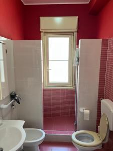 La salle de bains est pourvue de toilettes, d'un lavabo et d'une fenêtre. dans l'établissement 2 Min dal Mare - Alloggio con Patio Privato e BBQ, à Triscina