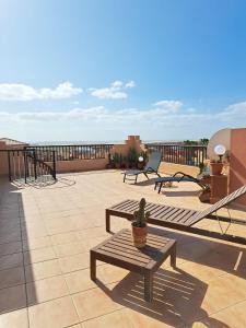 een patio met banken en tafels op een dak bij Ático Estrella sunset in Corralejo