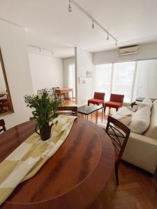 uma sala de estar com uma mesa e um sofá em Coqueto departamento en Recoleta em Buenos Aires