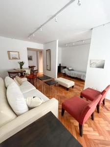 uma sala de estar com um sofá branco e cadeiras vermelhas em Coqueto departamento en Recoleta em Buenos Aires