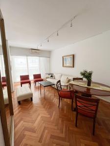 uma sala de estar com um sofá, uma mesa e cadeiras em Coqueto departamento en Recoleta em Buenos Aires