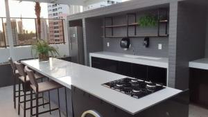 a kitchen with a stove and a counter top at Urbani Smart Residence in João Pessoa
