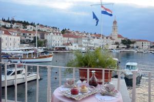 a table with food on a balcony next to the water at Castel Nonna Franka in Sutivan