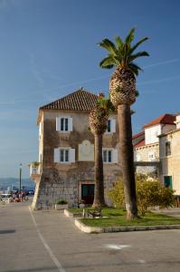 two palm trees in front of a building at Castel Nonna Franka in Sutivan