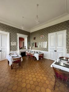 a dining room with tables and chairs in it at Gîte chaumière château de la Bouchatte in Chazemais