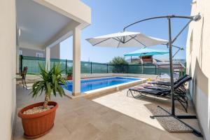 a villa with a swimming pool and a patio at Apartment Renata + PRIVATE swimming pool in SPLIT in Split