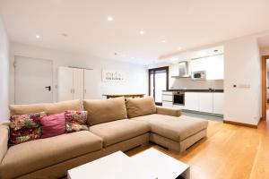 a living room with a couch and a kitchen at Guadalupe by Basquelidays in Hondarribia
