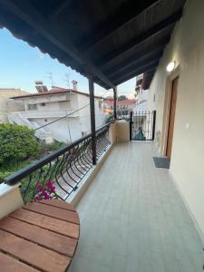 a balcony of a house with a bench on it at Evi's apartment Pefkochori in Pefkochori