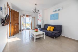 a living room with a blue couch and a table at Ciel Blue Villas in Kiotari