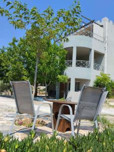 two chairs and a table in front of a building at el castle in Agioi Apostoli