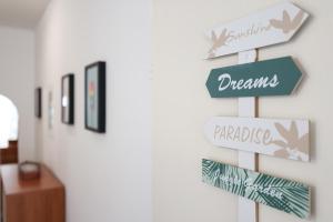um sinal que diz sonhos e paraíso numa parede em Apartment Mirta em Privlaka