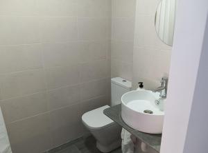 a bathroom with a white toilet and a sink at PENSION IRATI in Rincón de Soto +27 photos