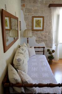 a bedroom with a bed and a stone wall at Castel Nonna Franka in Sutivan