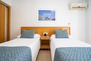 duas camas num quarto de hotel com vista para a Ópera sydney em Hostal RR Feria by Beleret em Valência