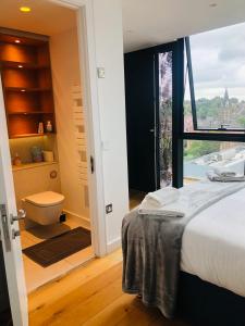 um quarto com uma cama e uma casa de banho com um WC em Luxury 2 bedroom apartment 20 min from central London em Londres