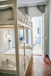 um quarto beliche com 2 beliches e uma varanda em LOFT APART & HOSTAL Group em Lloret de Mar