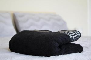 a pile of black towels sitting on a bed at Tinto View Apartment in Carstairs