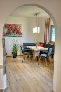 a dining room and living room with a table and chairs at Haus Oberautal in Achenkirch