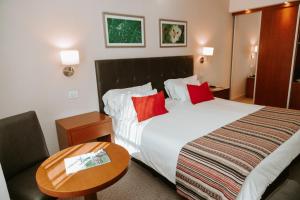 ein Hotelzimmer mit einem großen Bett und einem Tisch in der Unterkunft Howard Johnson Hotel Yerba Buena in Yerba Buena