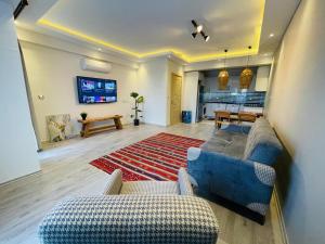 een woonkamer met een bank en stoelen en een tv bij Infinity Suites in Fethiye