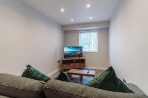 a living room with a couch and a flat screen tv at Contemporary 1 Bedroom Apartment in Liverpool in Liverpool