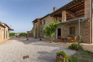a courtyard of a building with a table and chairs at Agriturismo I Savelli in Castiglione dʼOrcia