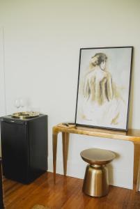 une peinture d'une femme sur une table avec un tabouret dans l'établissement Bellview Luxury Suites, à Baddeck