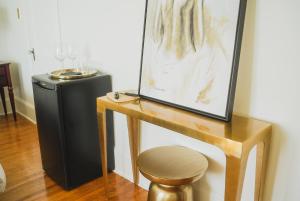 une table avec un tabouret et une photo sur le mur dans l'établissement Bellview Luxury Suites, à Baddeck